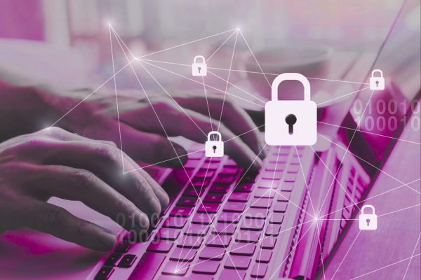 Person using a laptop with padlock icons and a digital network overlay, illustrating cybersecurity, data traceability and blockchain applications